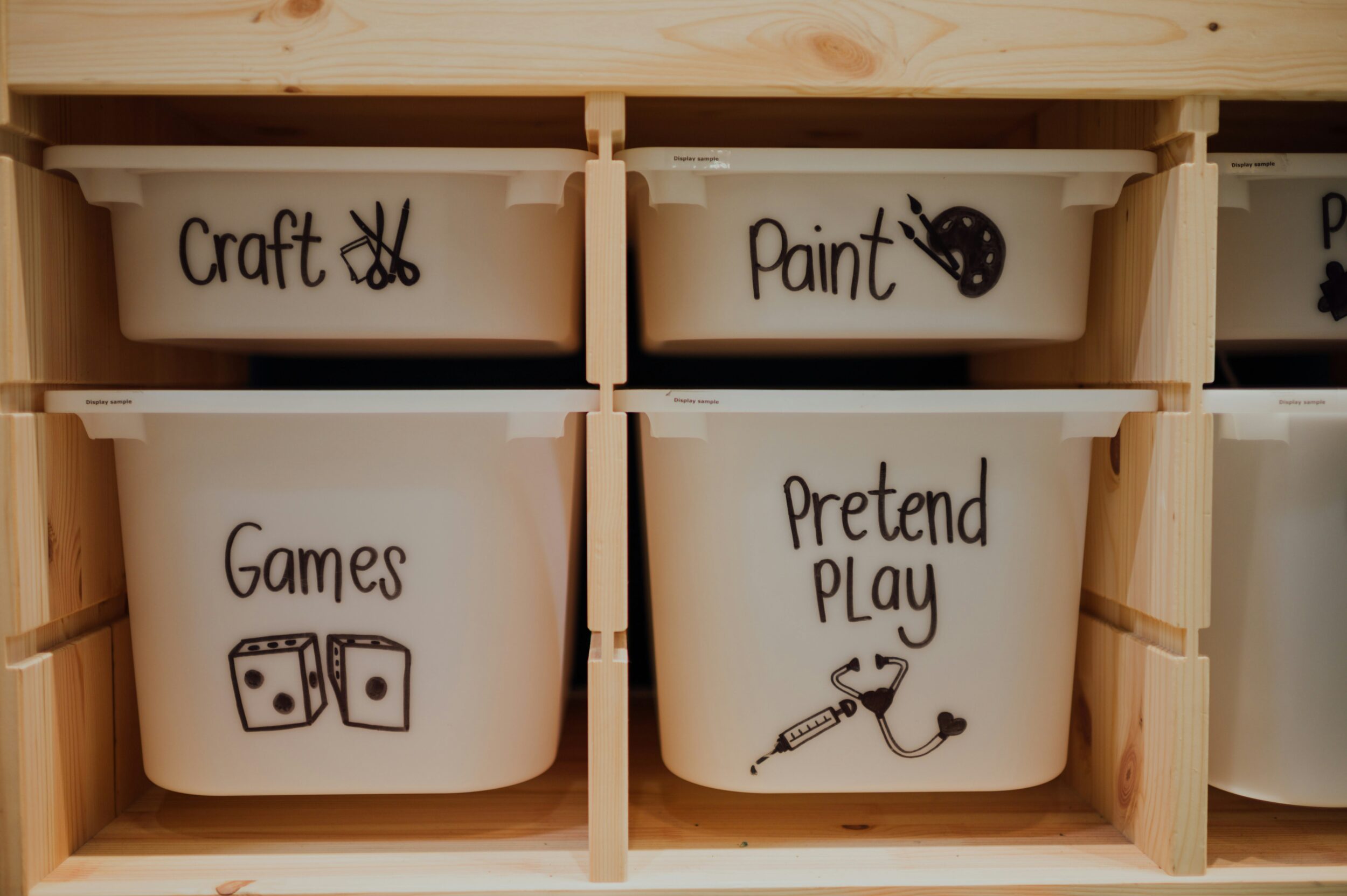 Four matching white toy bins with picture labels