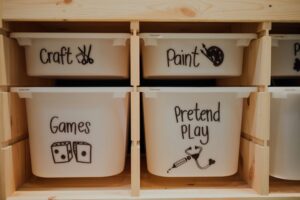 Four matching white toy bins with picture labels
