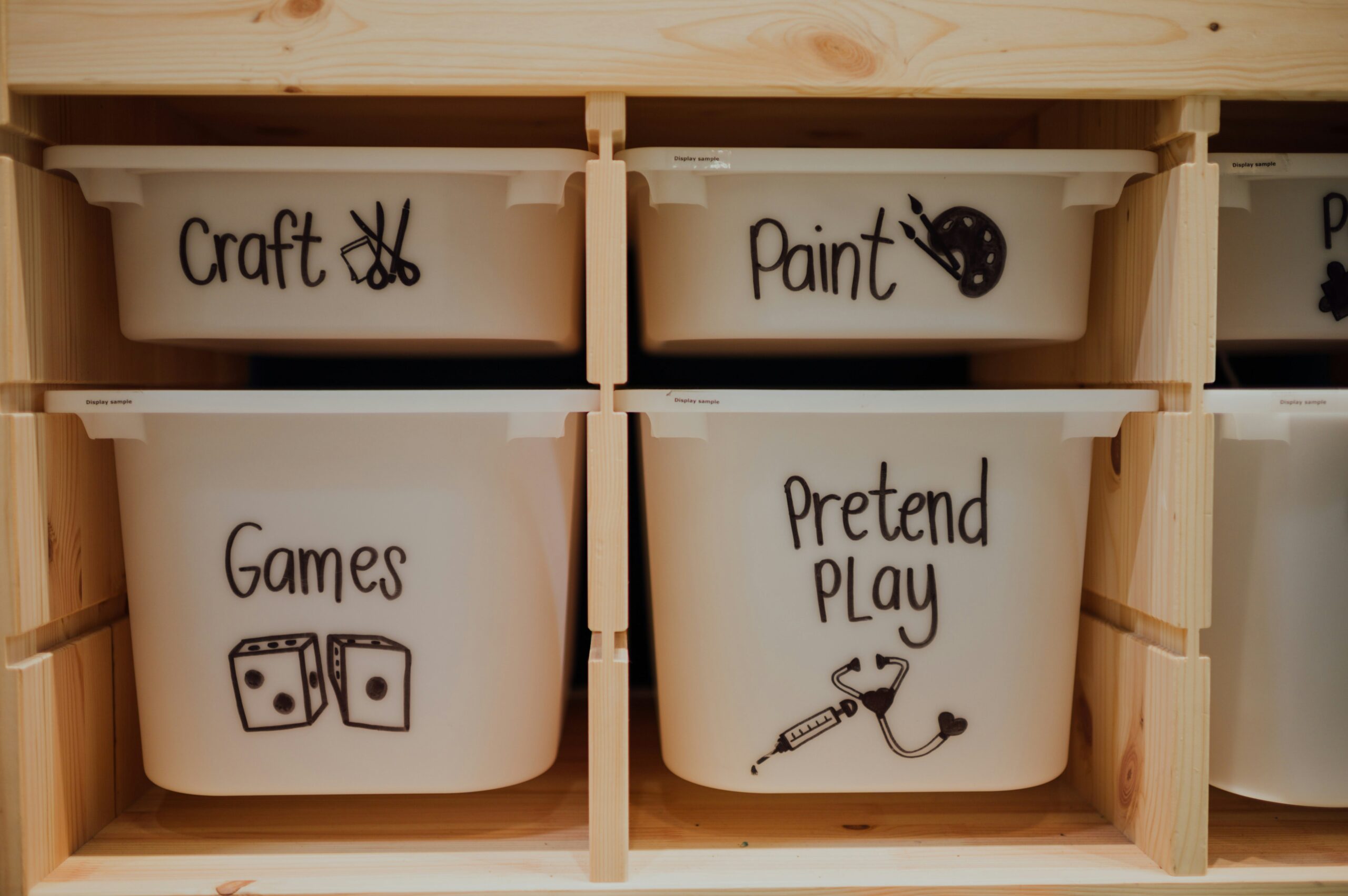 Four matching white toy bins with picture labels